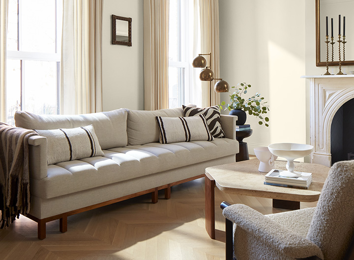 A sunlit, off-white painted living room with neutral decor.